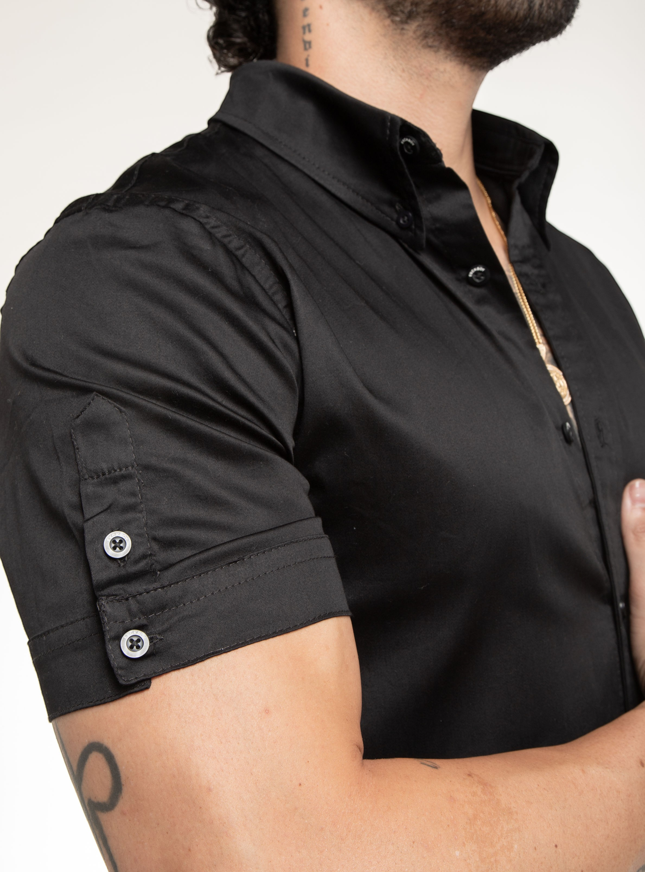 Fxckboy black satin stretch slim fit short sleeve shirt with raised collar and silver buttons.
